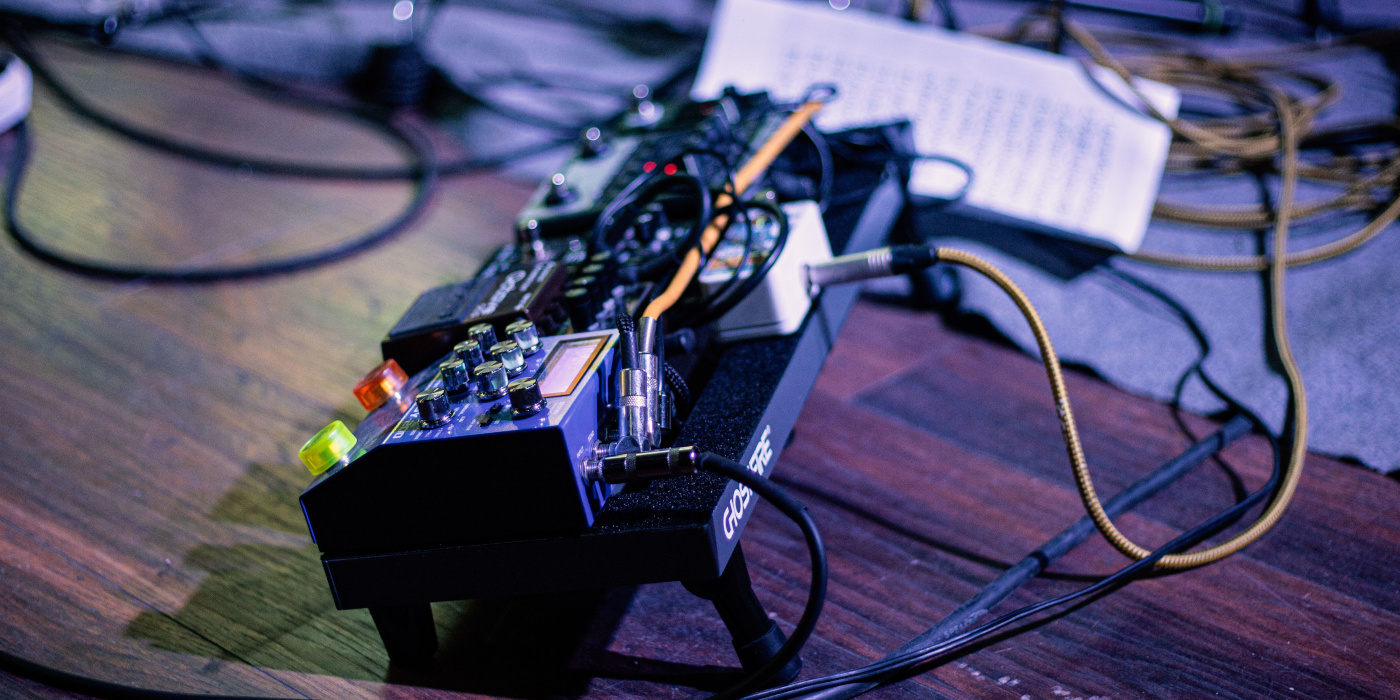 A small guitar pedalboard on a stage floor