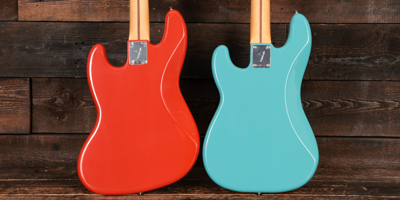 The back of Fender Jazz Bass and Precision Bass bodies side by side on wooden background