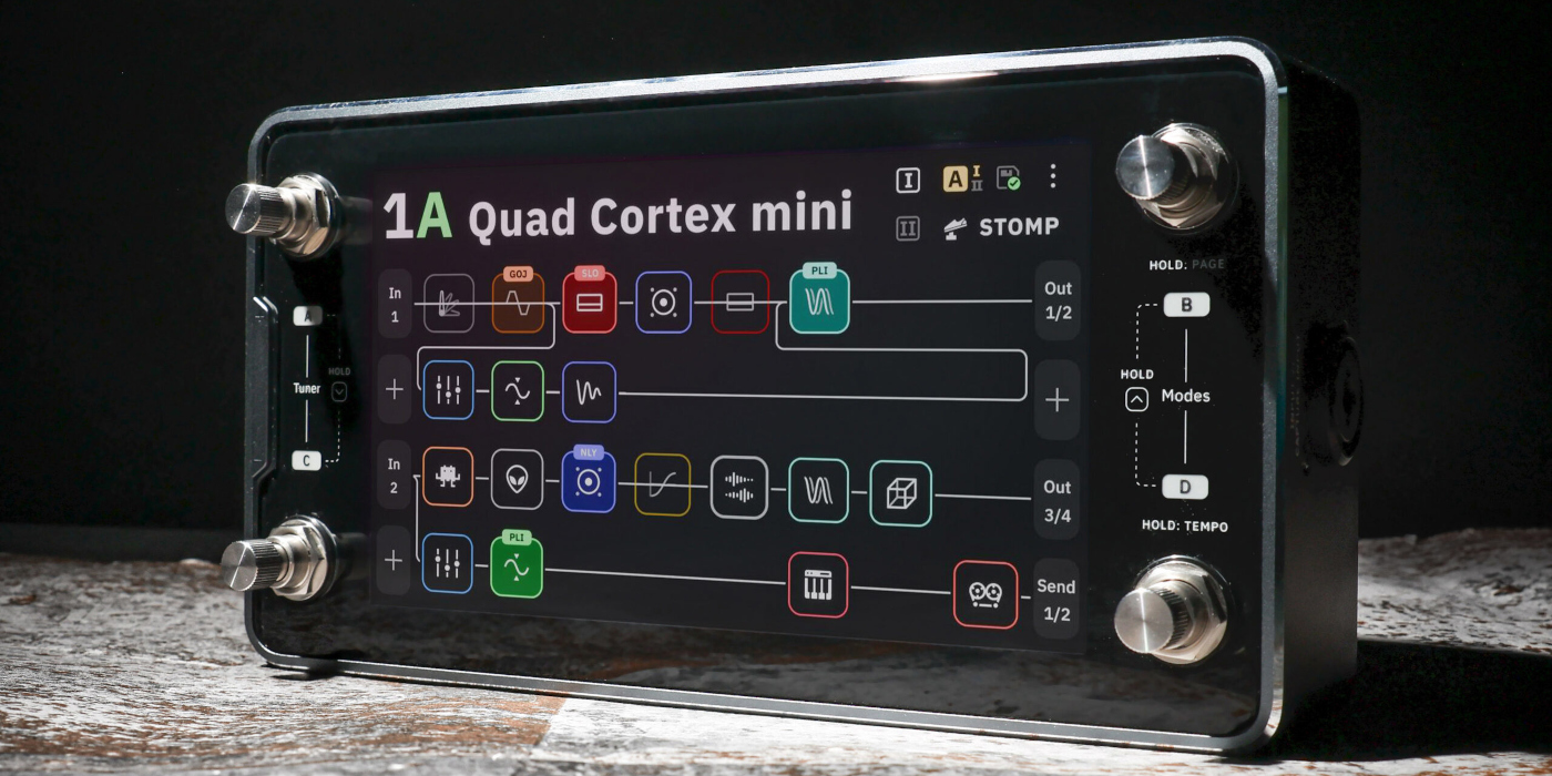 A close lifestyle photo of the Neural DSP Quad Cortex Mini with its screen illuminated showing a digital signal chain