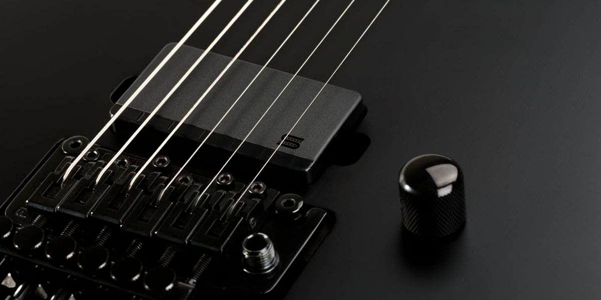 A close up photo of a Seymour Duncan MortalCoil active humbucker pickup released at NAMM Show 2026 in a black guitar with a Floyd Rose tremolo