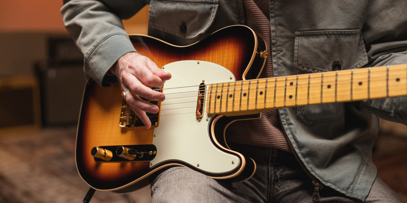 A male guitarist playing the Fender 75th Anniversary American Professional Custom Telecaster in a studio