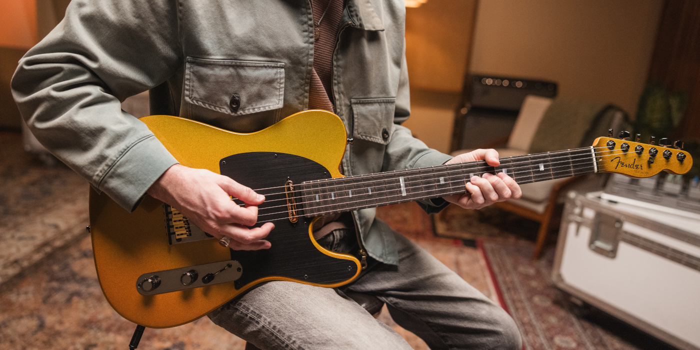 A male guitarist playing the Fender 75th Anniversary American Ultra II Telecaster in a studio