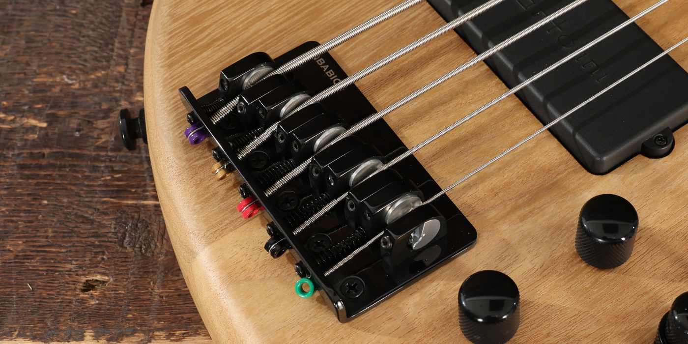 A close up photo of a Babicz FCH bridge on a Tobias Growler 5-string bass