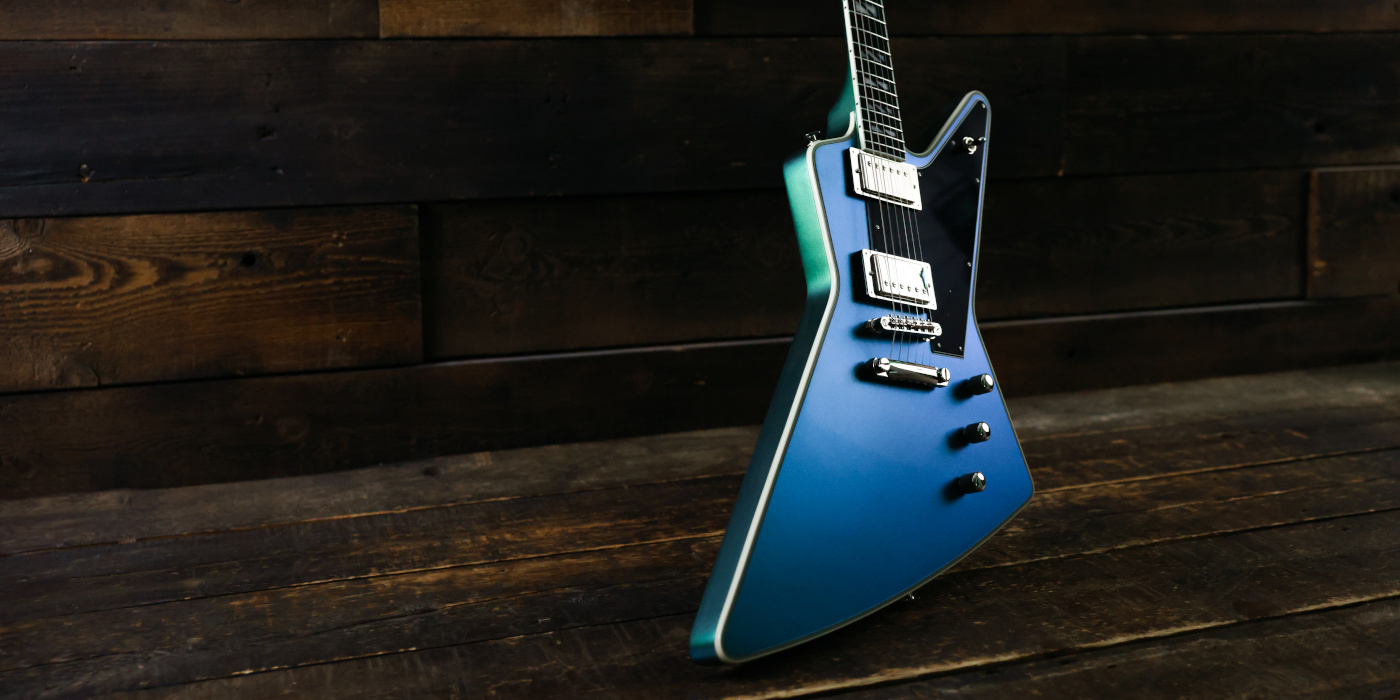 A photo of an angled Epiphone Futura Explorer in Dragonfly Shift against a dark wooden background