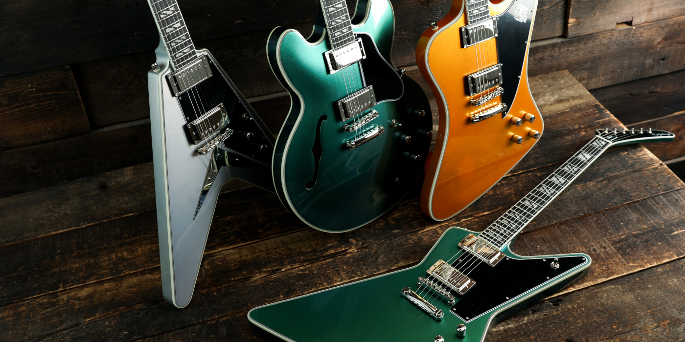 A group photo of four Epiphone Futura electric guitars against a dark wooden background