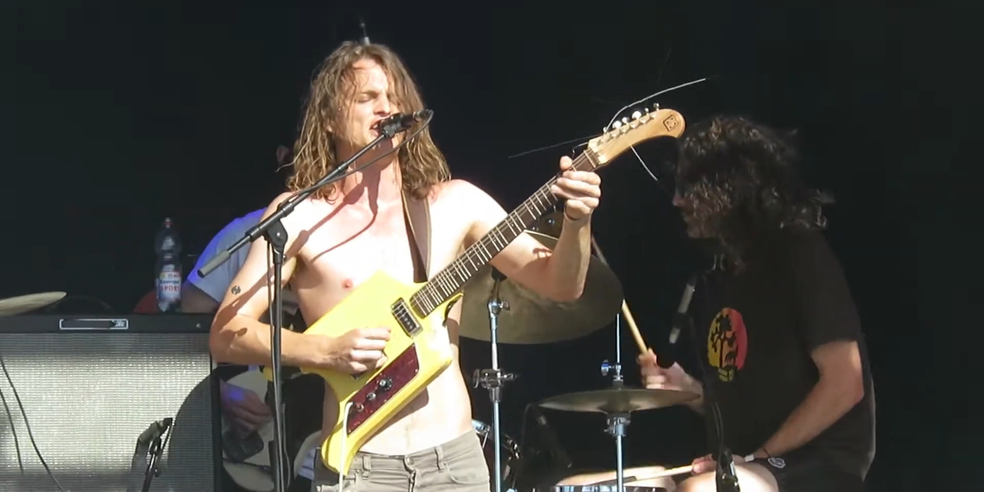 A photo of King Gizzard and the Lizard Wizard using a microtonal guitar on stage