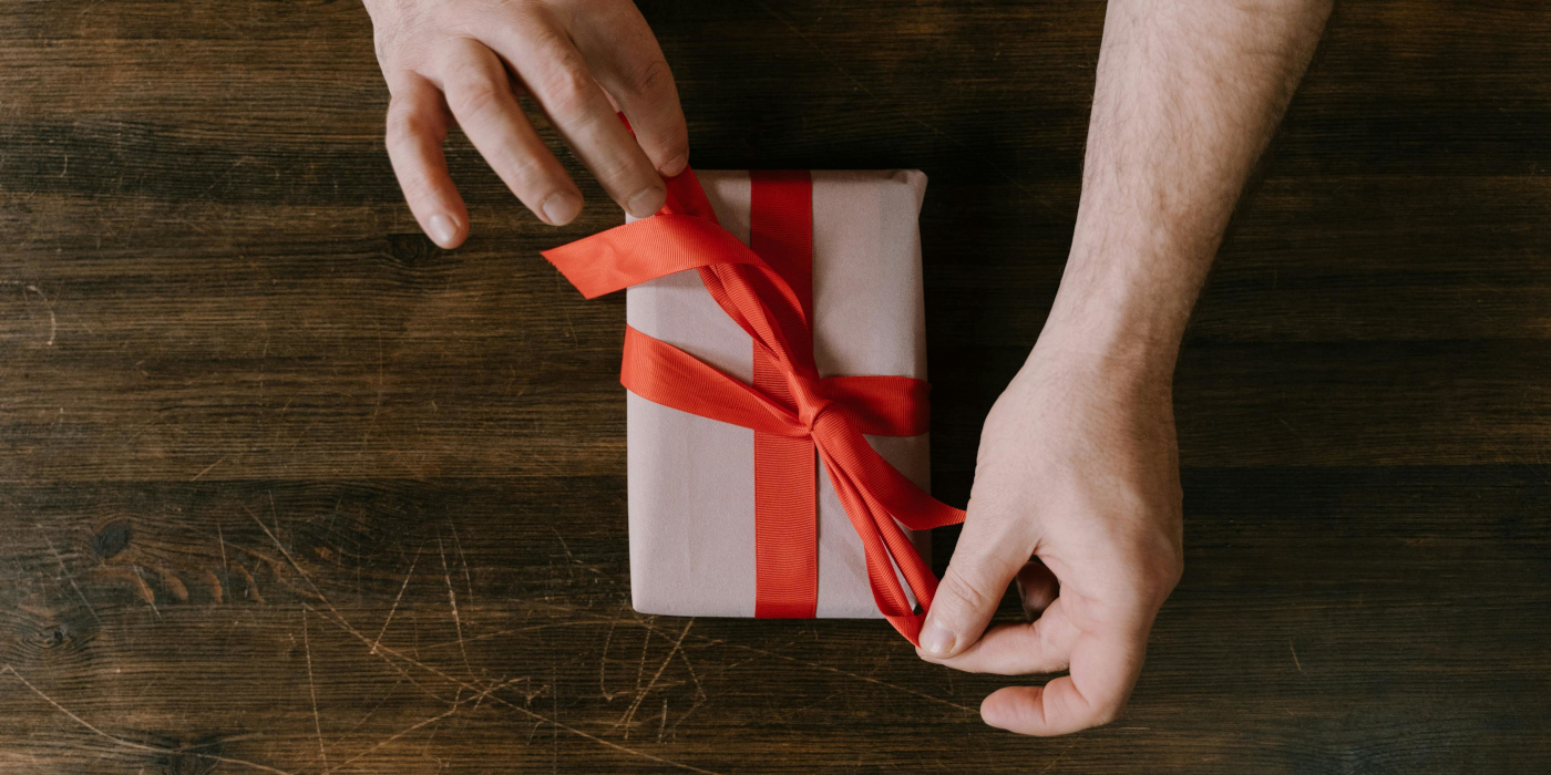 Man unwrapping a Father's Day present on a wooden table