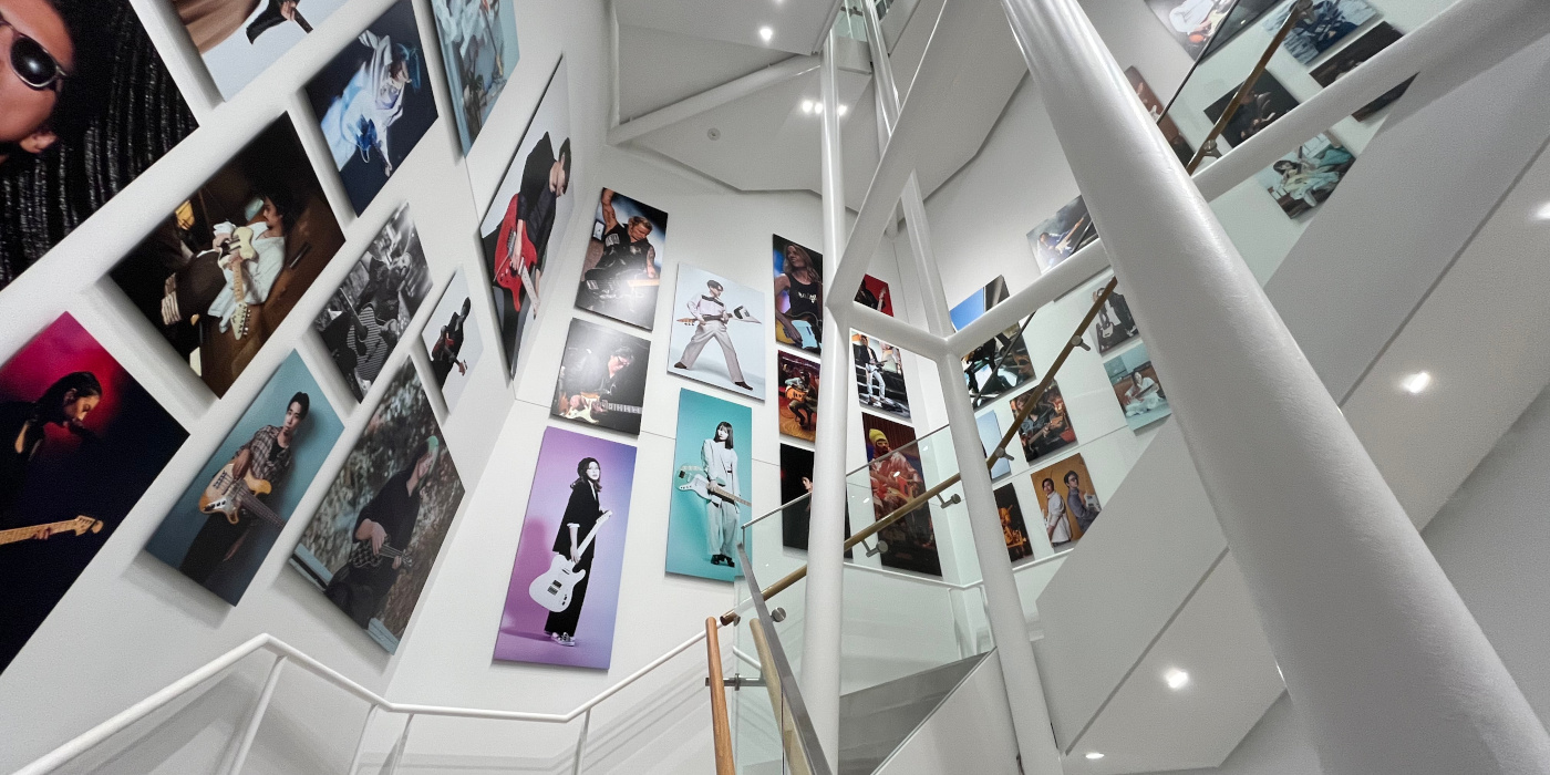 A photo of the main stairwell in the Fender Flagship Tokyo shop showing various artist prints on the walls