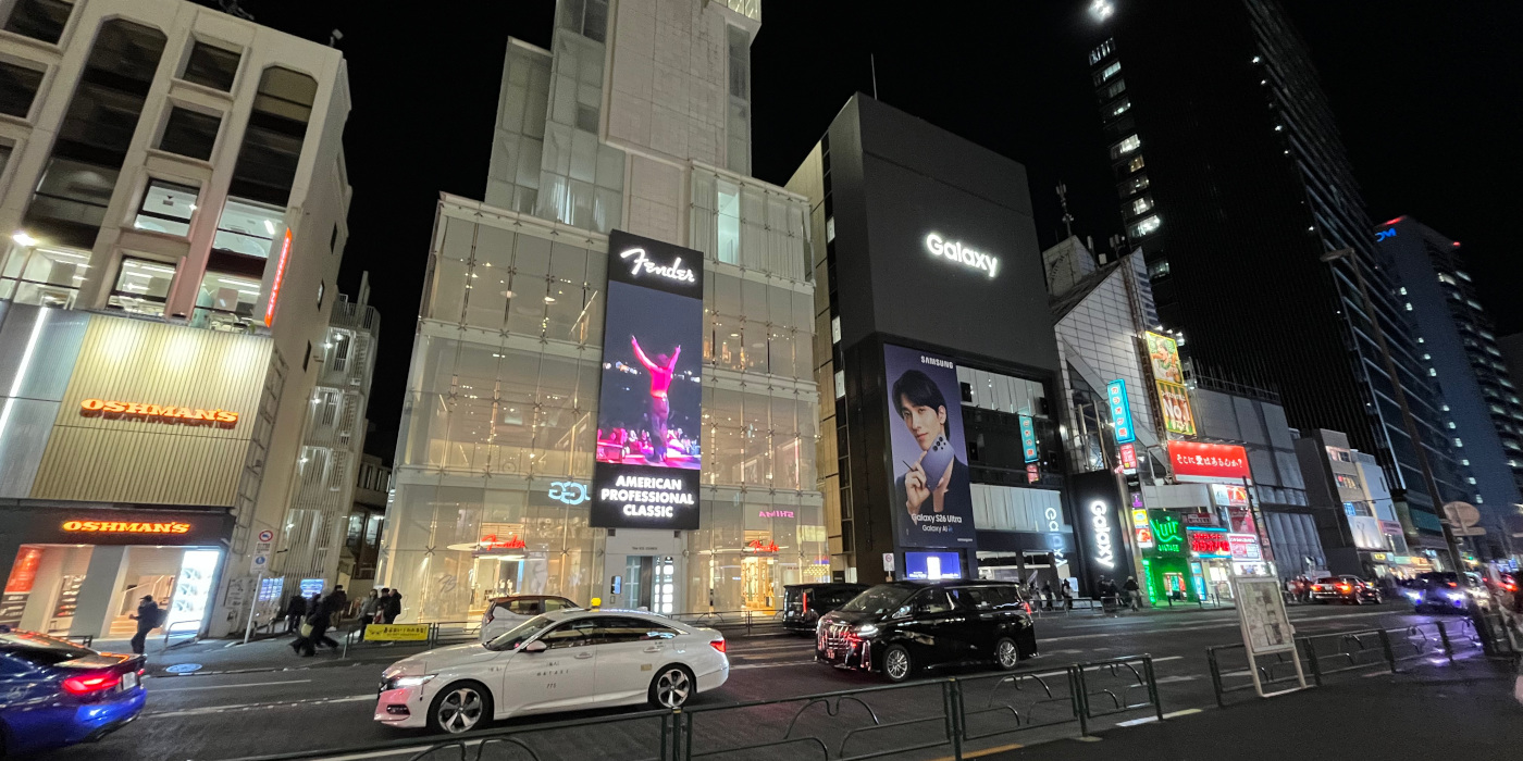 An angled photo of the illuminated Fender Flagship Tokyo storefront at night from the street outside