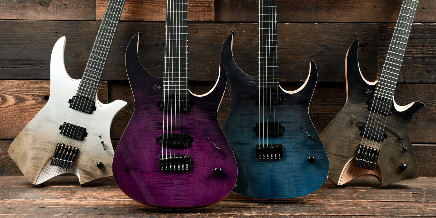 Four Infinia electric guitars next to each other on wooden background