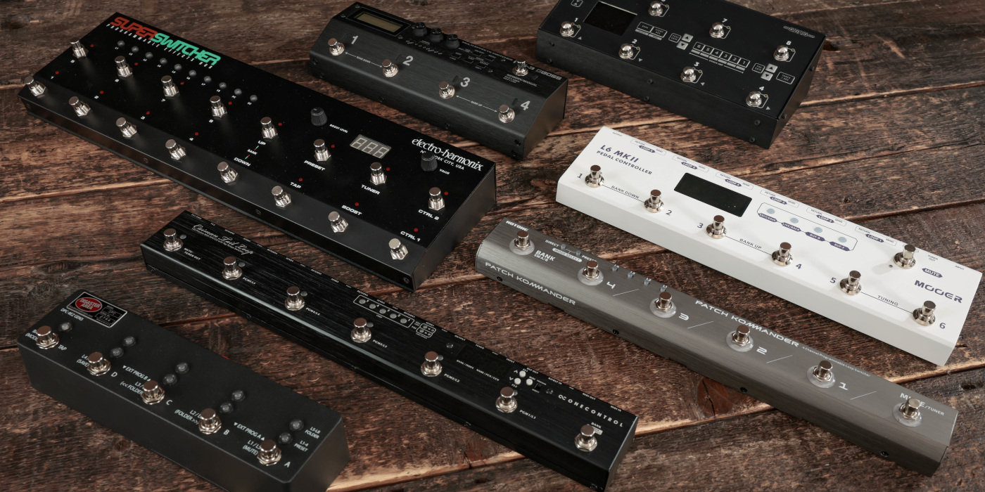 Various guitar pedal switchers laid out on a wooden floor