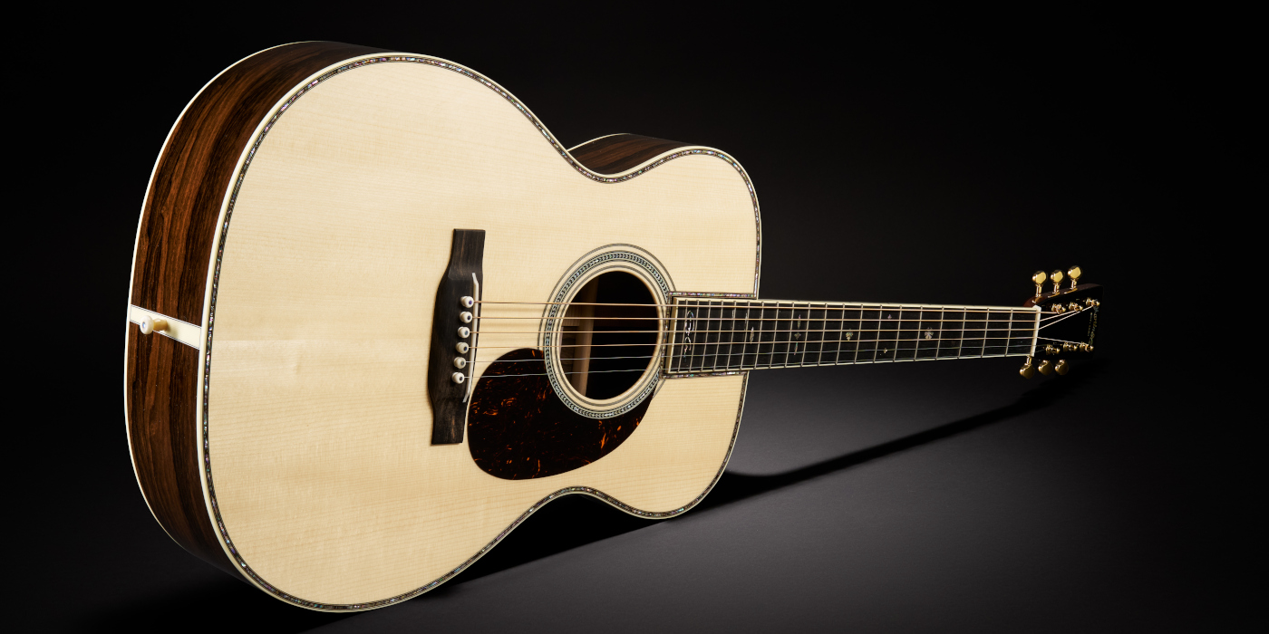 The Martin Custom Shop 000-42 Eric Clapton acoustic guitar in the Clear Natural finish on a dark textured background
