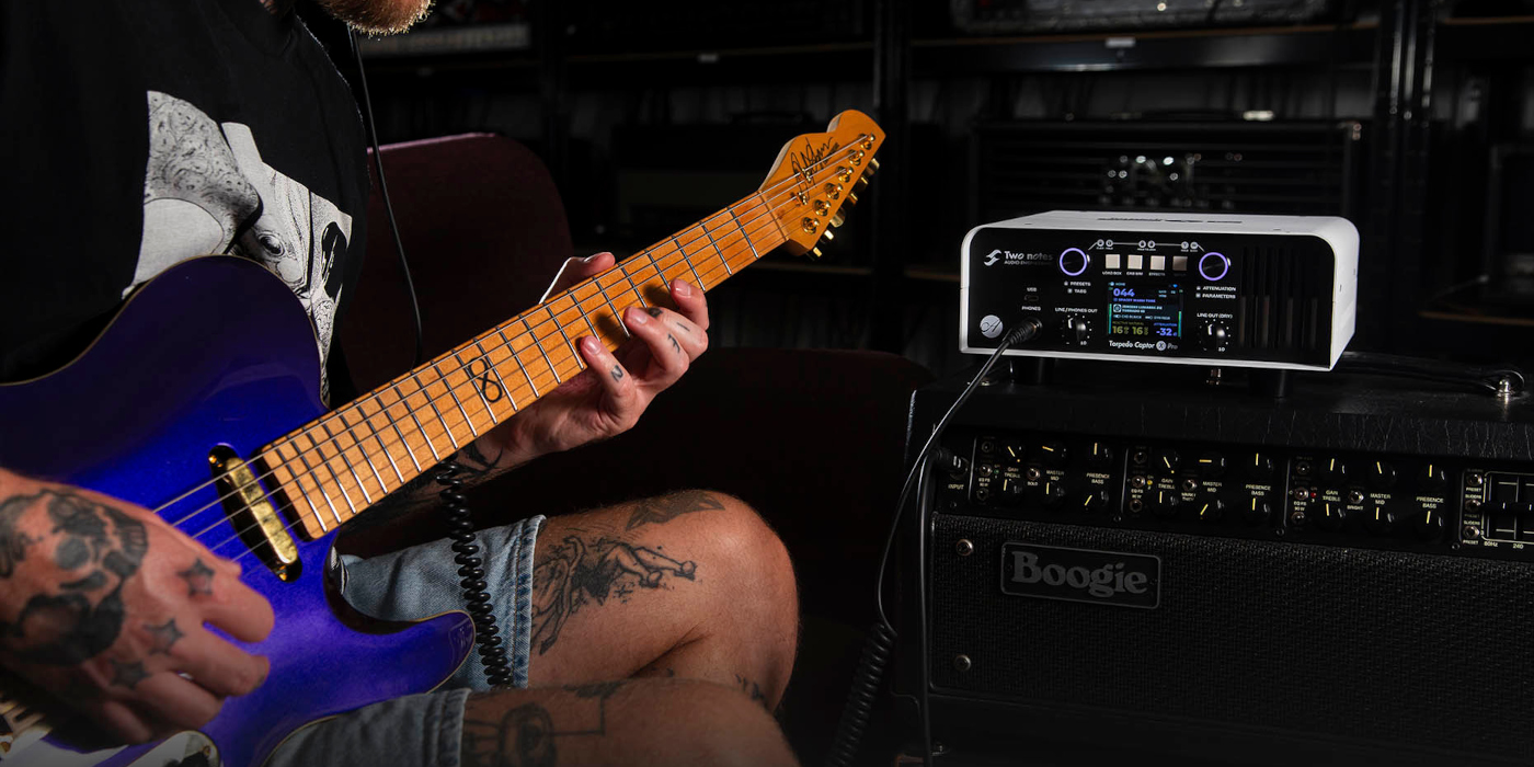Guitarist sitting in studio playing through amp and Two Notes Torpedo Captor X Pro