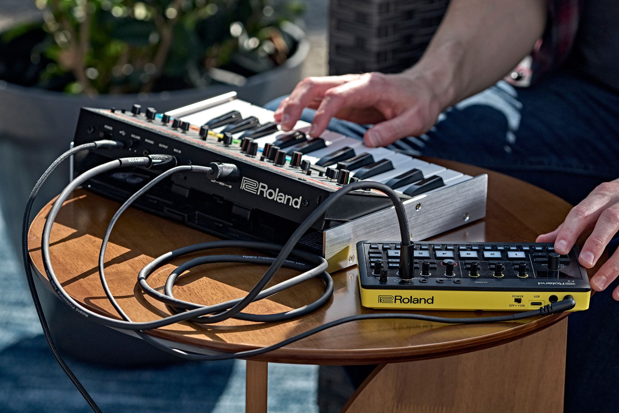 The rear of the Roland Jupiter-08 connected to the Roland Micro Aira Sampler .
