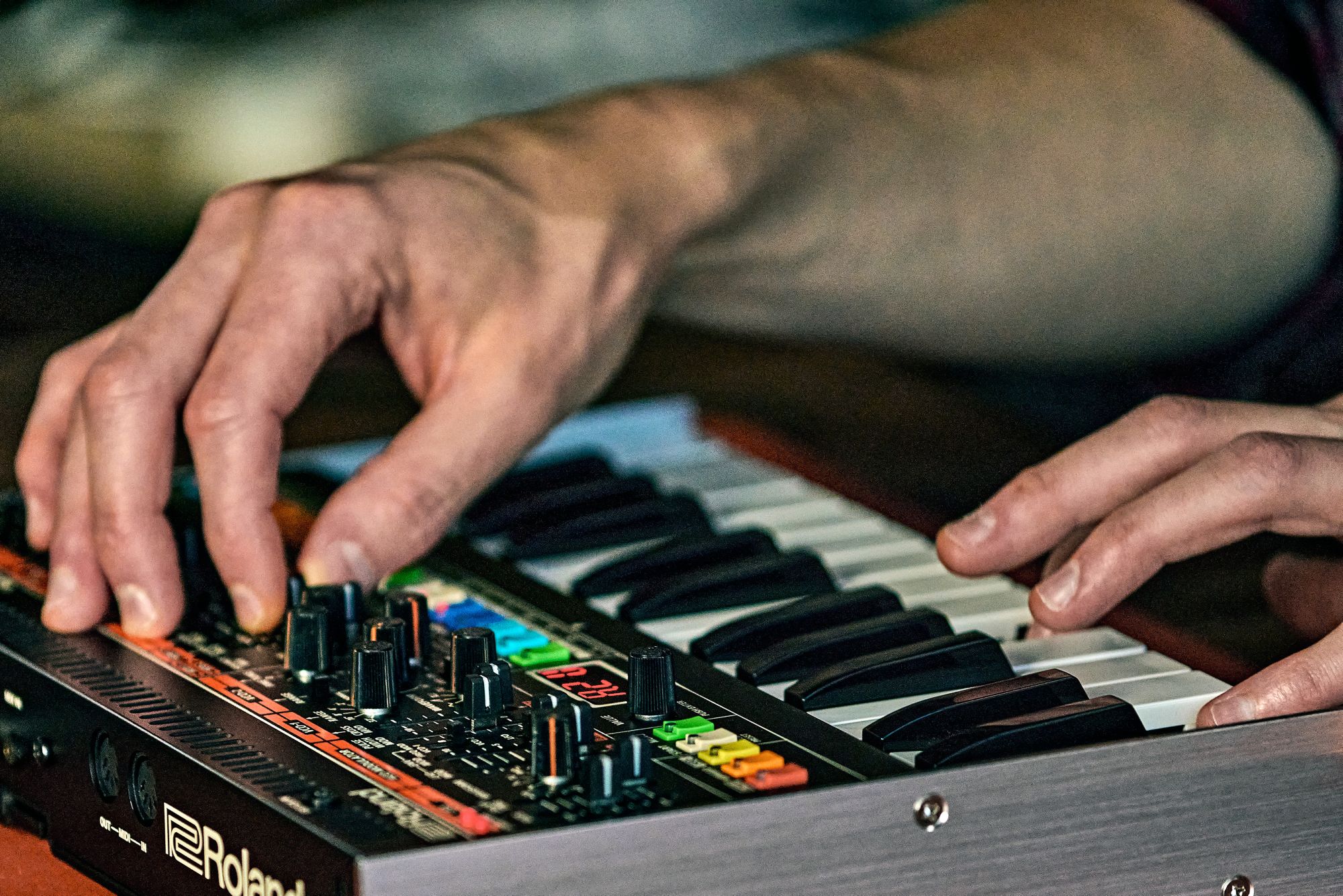 Close up of the Roland Jupiter-08 being played played on the keys whilst a control is being adjusted on the front panel.