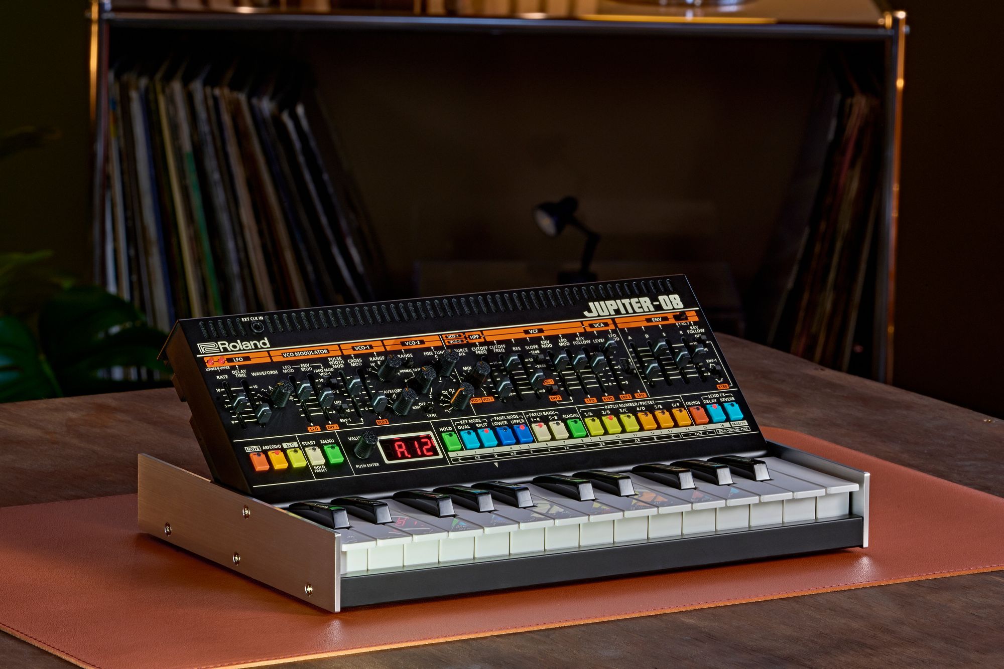 Photo of the Roland Jupiter-08 Boutique synth on a leather pad in a home music room. It showcases the colourful design that harks faithfully back to the original Roland Jupiter-8.